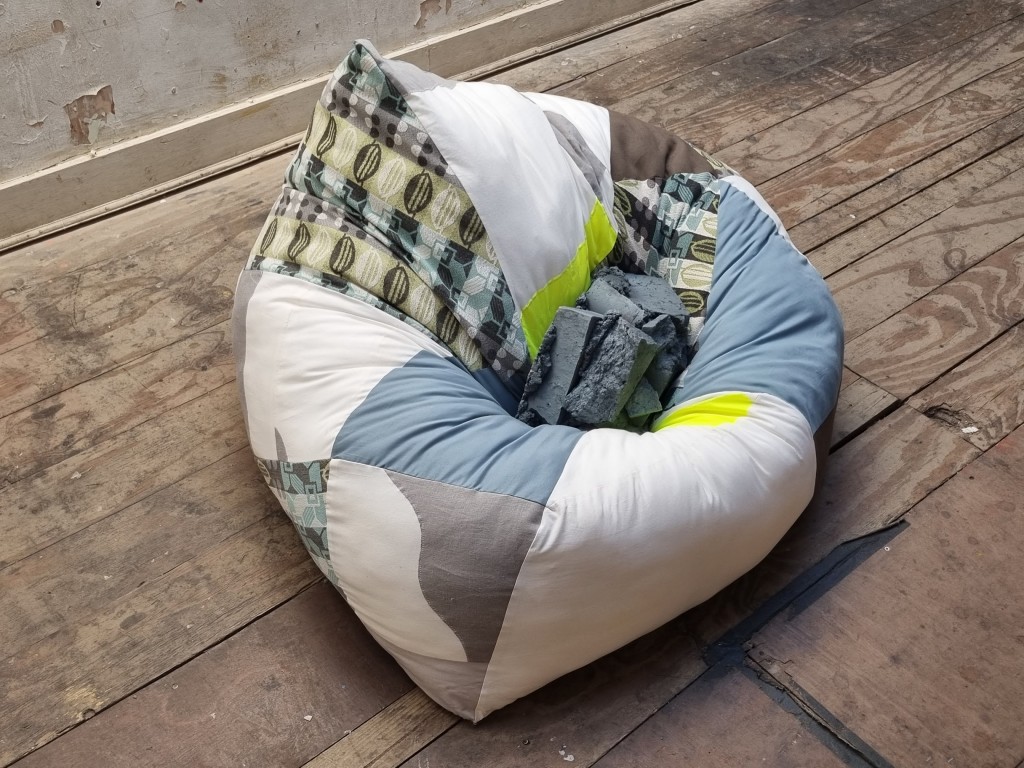 The weights we carry', 2022, stitched fabric, wadding, painted masonry